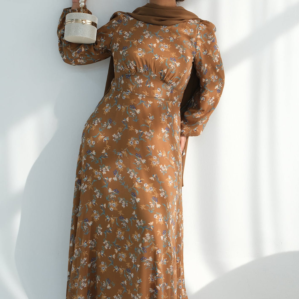 Woman in a brown floral dress holding a white container against a white background