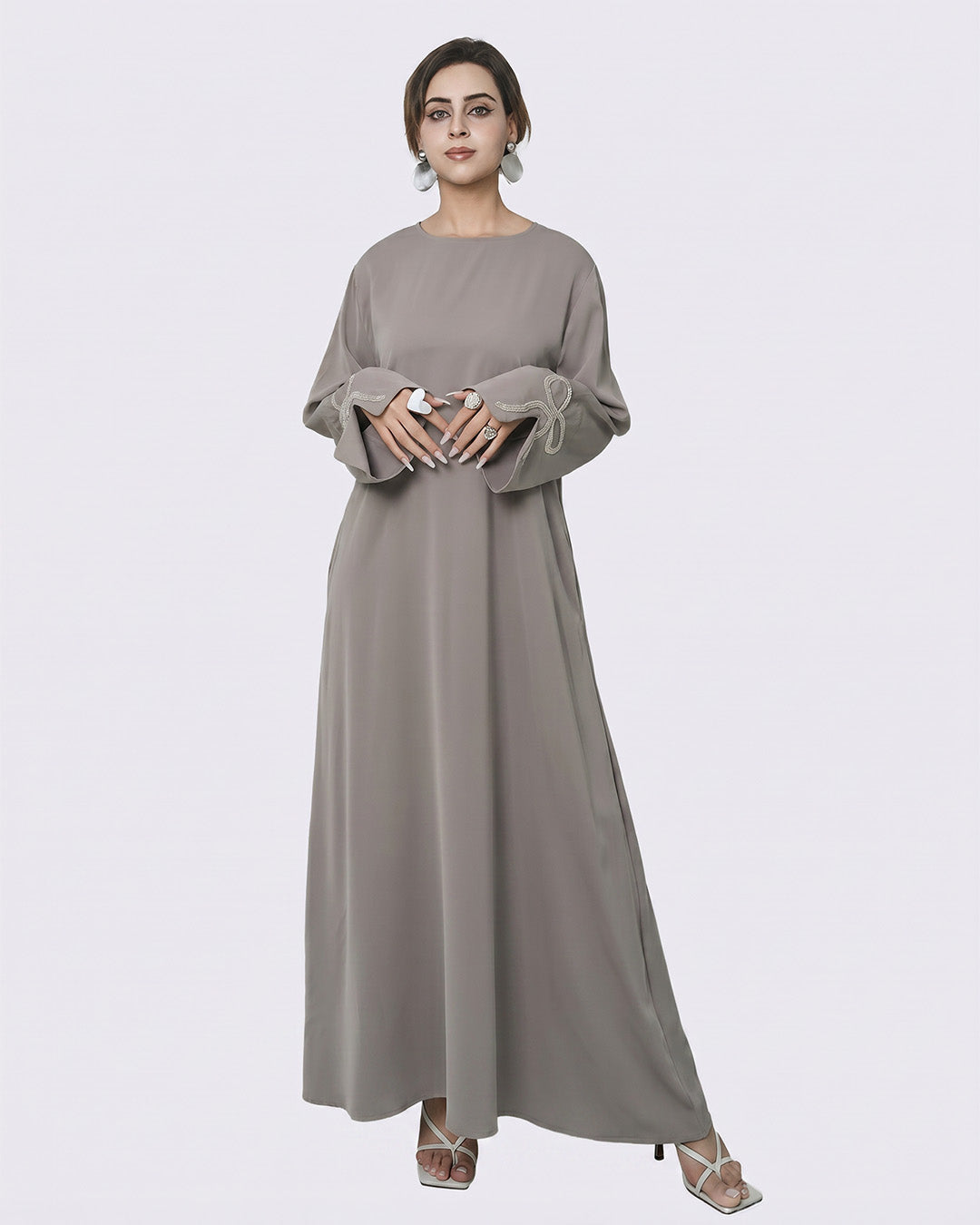 Woman wearing a long gray dress on a white background