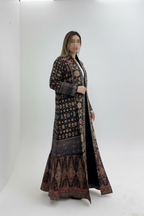 Shop trending stretchable fabric abayas available in many elegant colors. Soft, flexible, and comfortable abayas perfect for everyday wear, work, and travel. Long, patterned coat worn by a person on a white background
