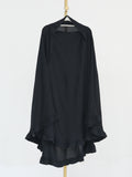 A black long-sleeve draped top with layered ruffle hems, hanging on a black hanger from a gold-colored stand against a plain white background.