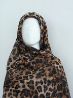 A leopard print headscarf draped on a white mannequin head, set against a plain light gray background.