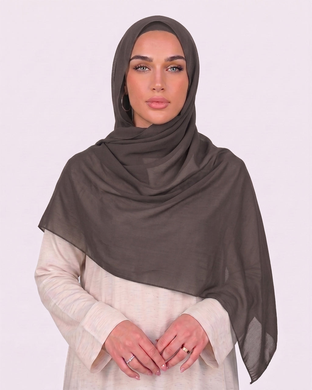 Model wearing a lightweight, dovetail chiffon hijab wrapped elegantly over a beige long-sleeved dress.