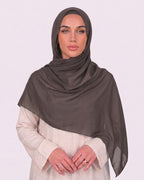 Model wearing a lightweight, dovetail chiffon hijab wrapped elegantly over a beige long-sleeved dress.