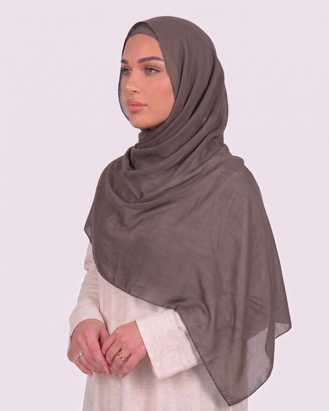 Model wearing a lightweight, dovetail chiffon hijab wrapped elegantly over a beige long-sleeved dress.