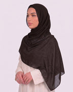 Model wearing a lightweight, espresso chiffon hijab wrapped elegantly over a beige long-sleeved dress.