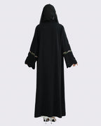 Black abaya with gold embroidery on a white background