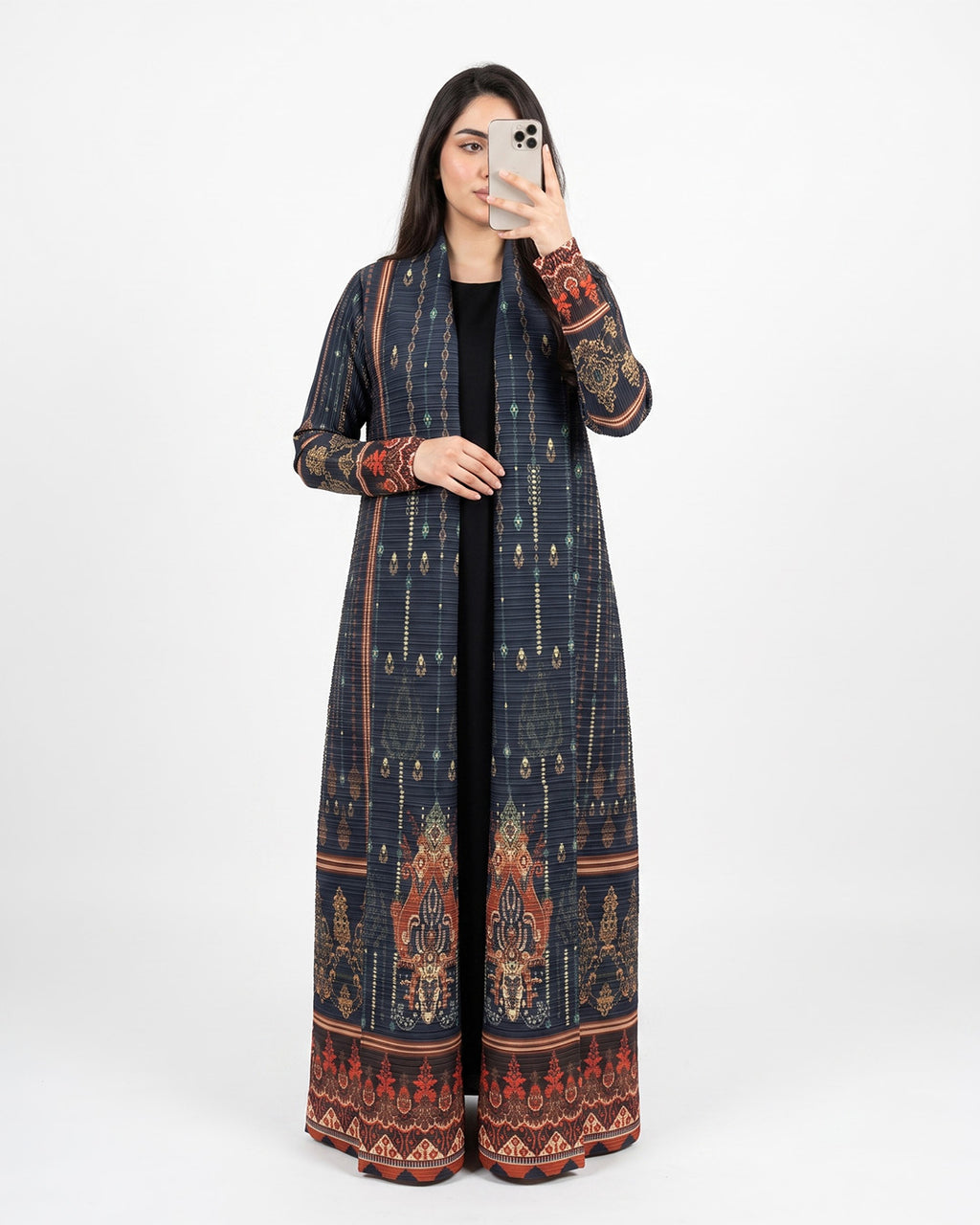 A woman takes a mirror selfie wearing a long navy blue printed kurta with intricate red, gold, and brown patterns, paired with a black top and a black skirt.