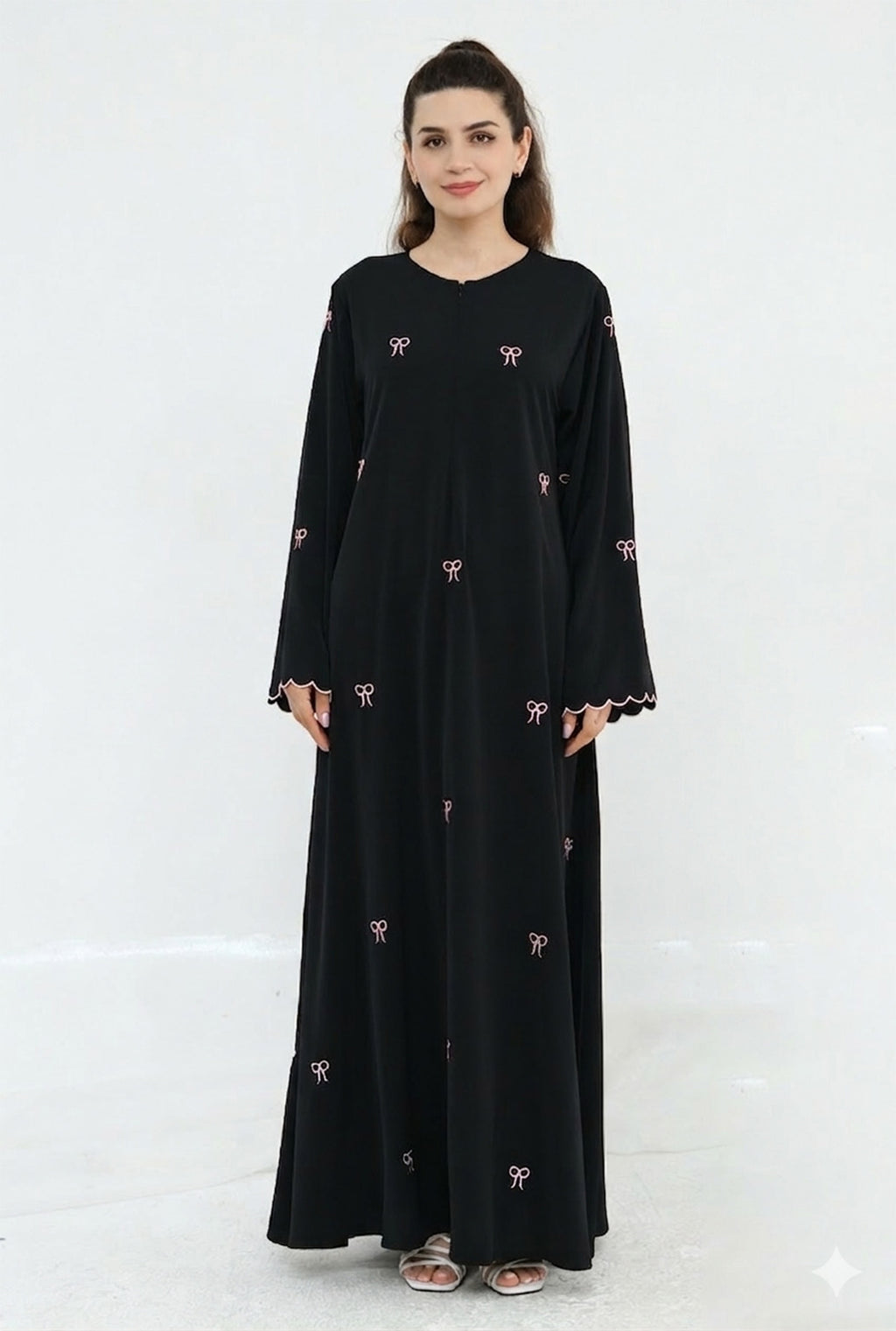 Woman wearing a black dress with white patterns on a white background