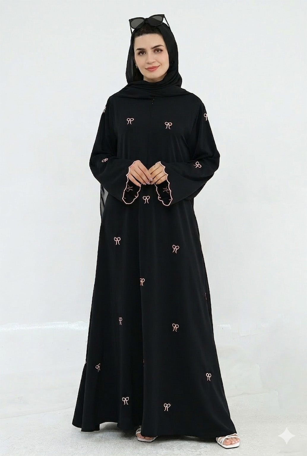 Woman wearing a black abaya with embroidery on a white background