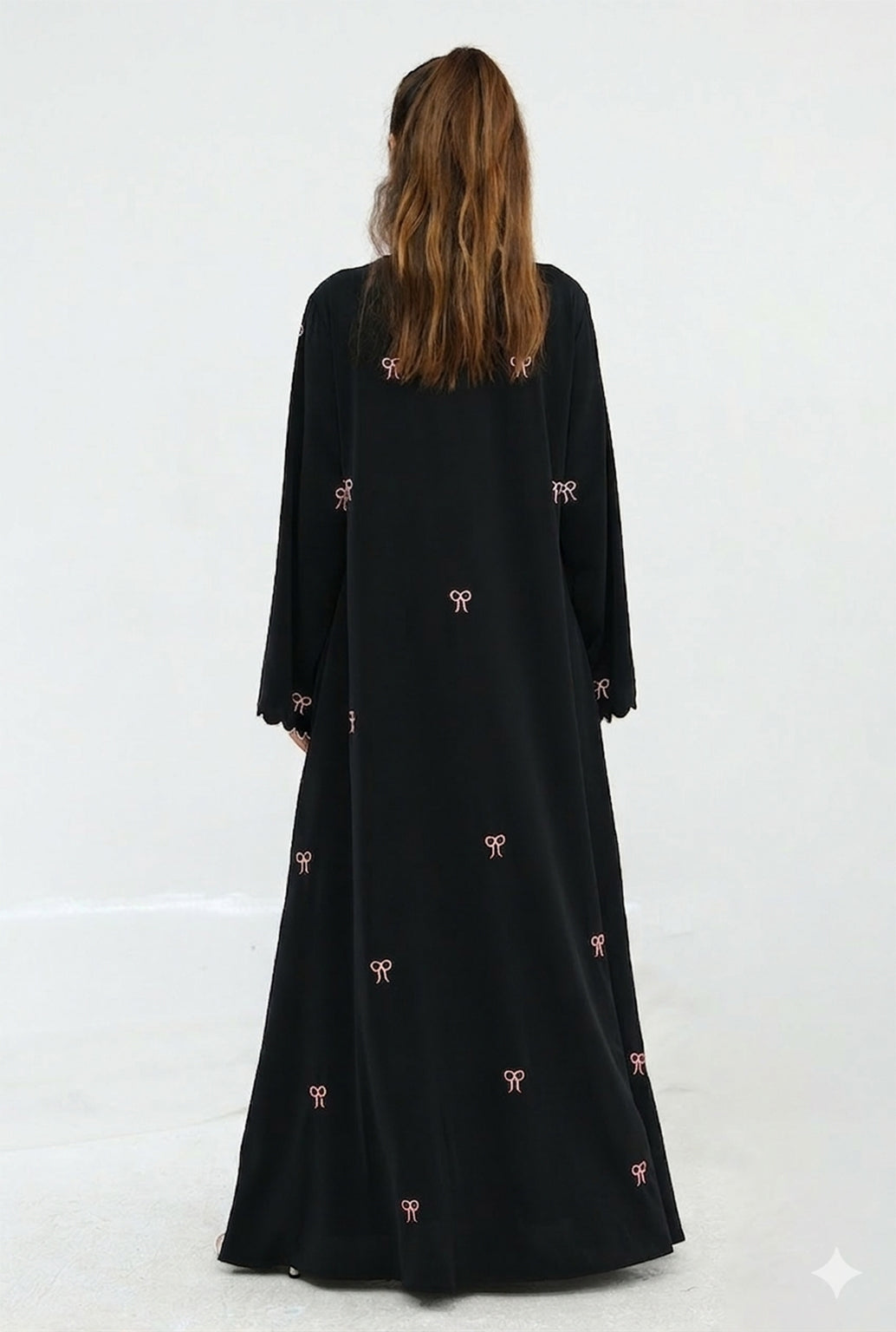 Black long-sleeve dress with pink floral patterns on a white background