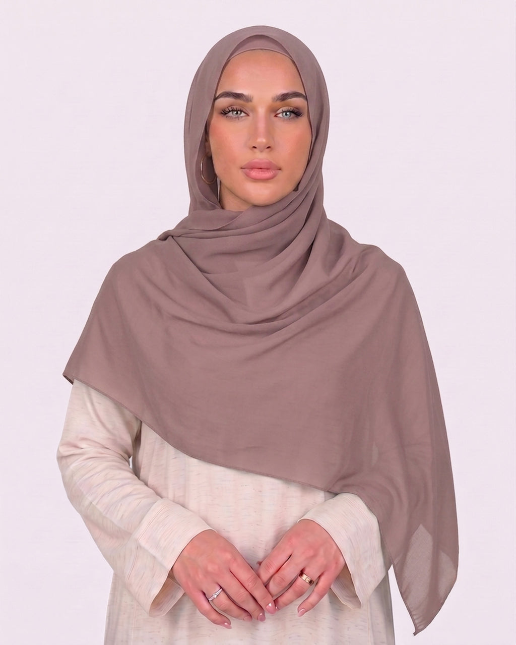 Model wearing a lightweight, nude muave chiffon hijab wrapped elegantly over a beige long-sleeved dress.