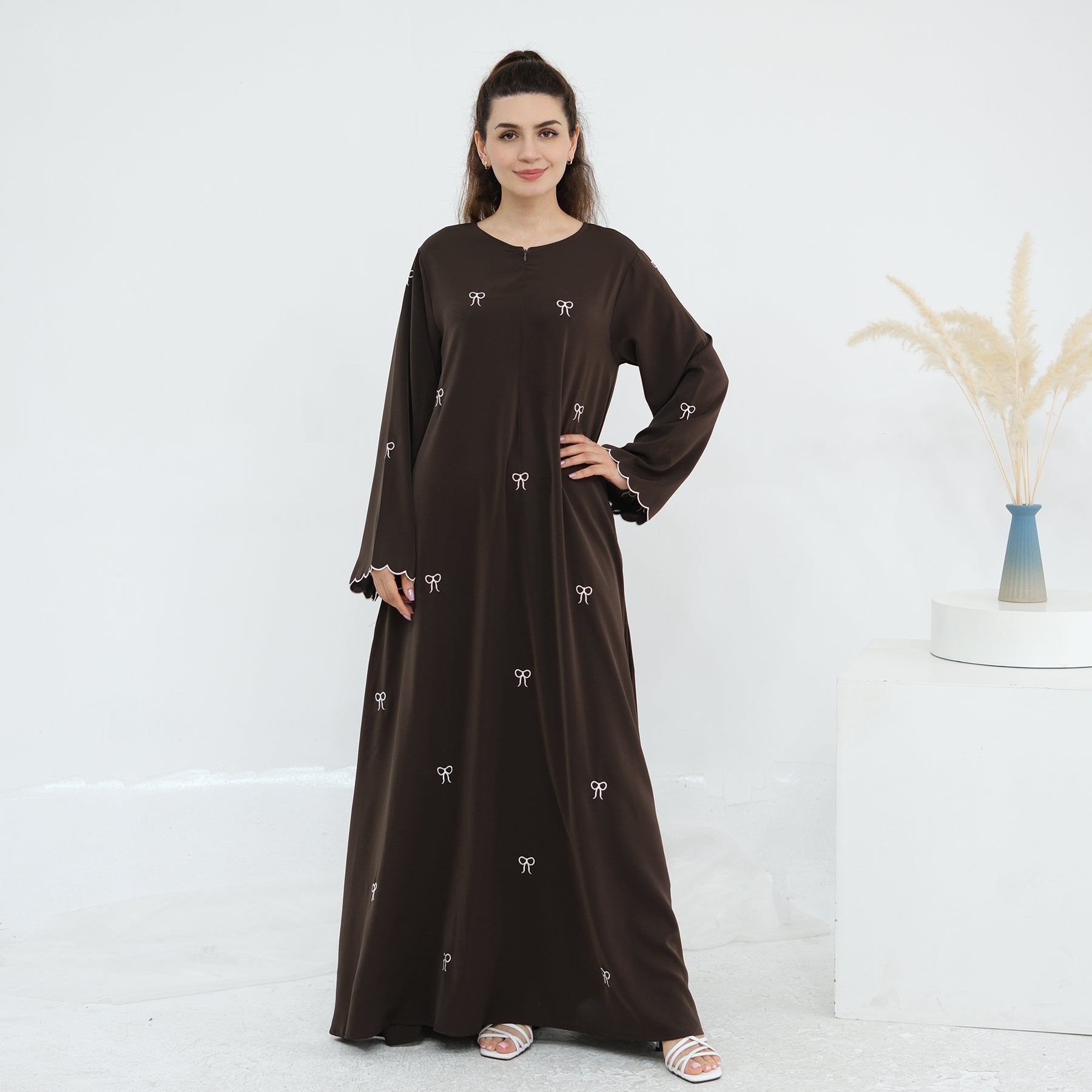 Black abaya with white embroidery on a white background