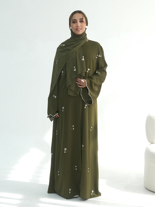 A mannequin wearing a dusty rose , army green and coffee abaya and matching hijab, shown from the back. The abaya features small white embroidered details scattered across the fabric.