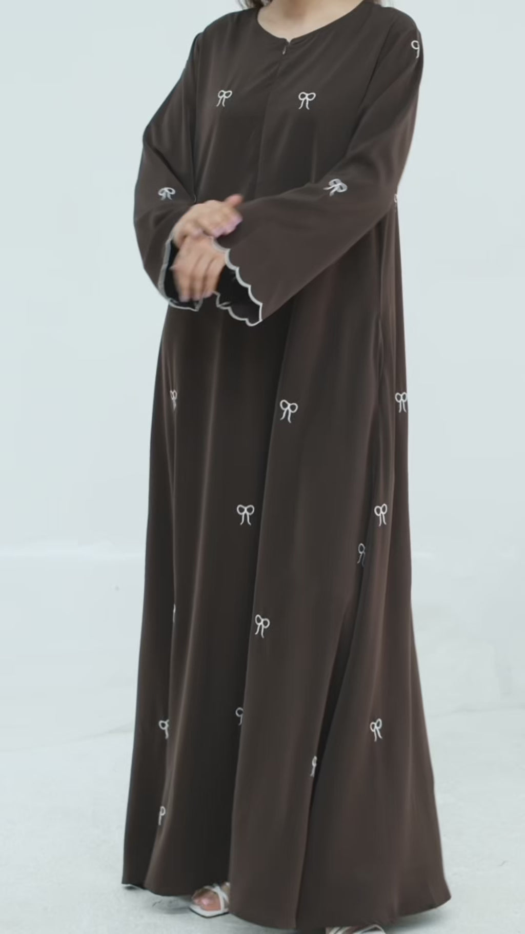 Black abaya with white embroidery on a white background