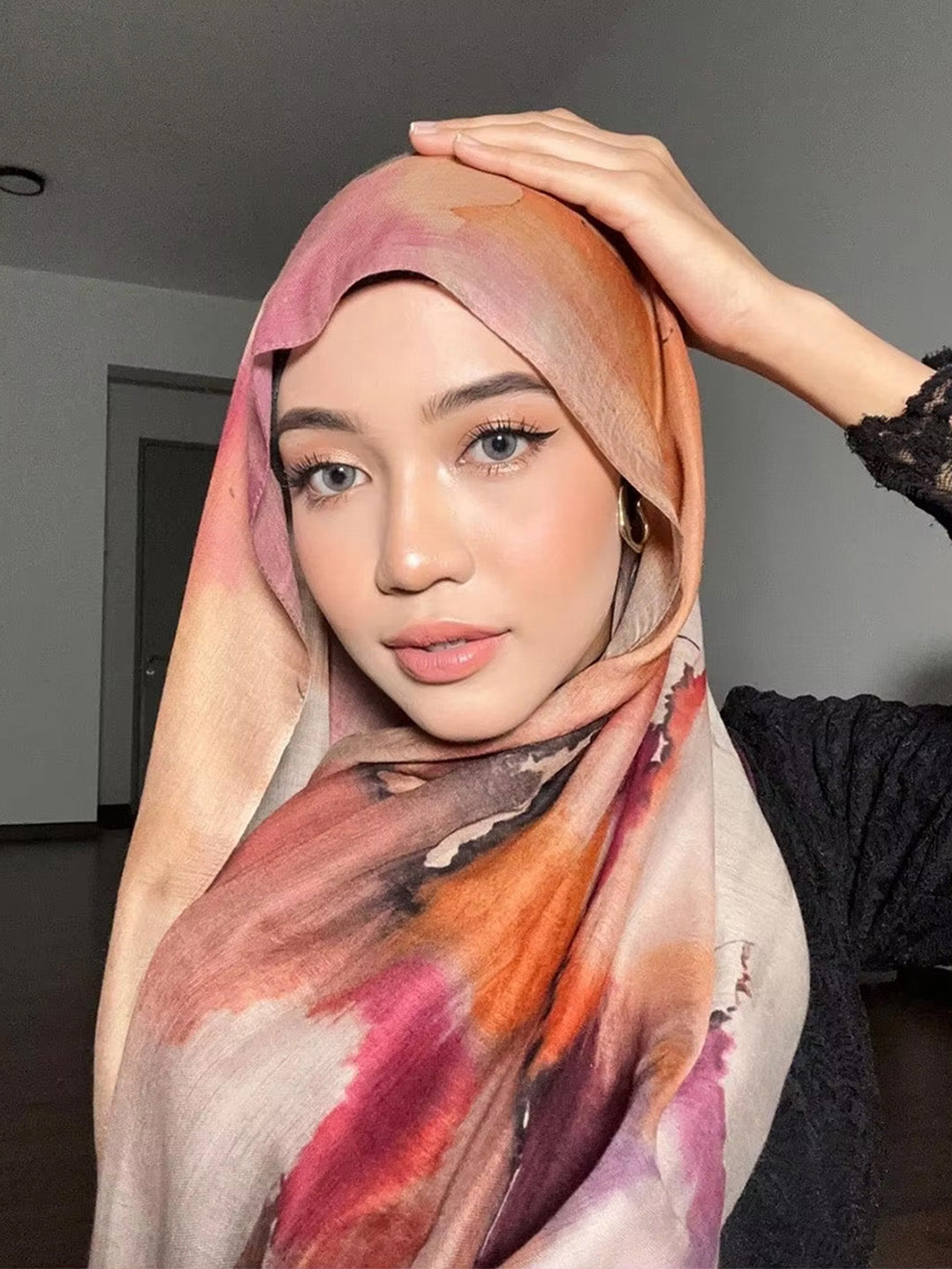 Woman wearing a colorful hijab with a neutral background