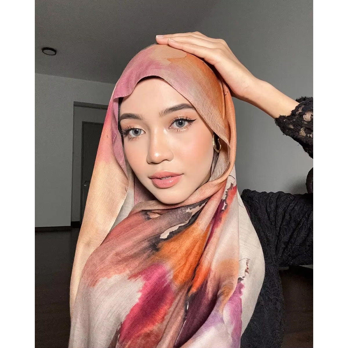 Woman wearing a colorful hijab with a neutral background