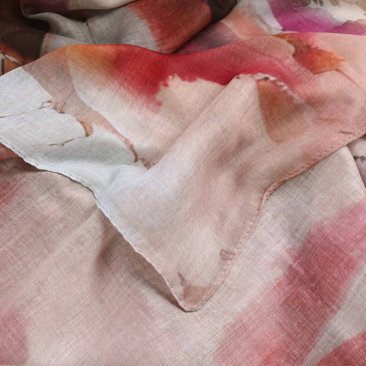 Close-up of a fabric with watercolor-style red and pink design