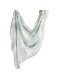 A lightweight, semi-sheer scarf with a watercolor-style abstract print in soft sage green and white, draped against a solid white background.