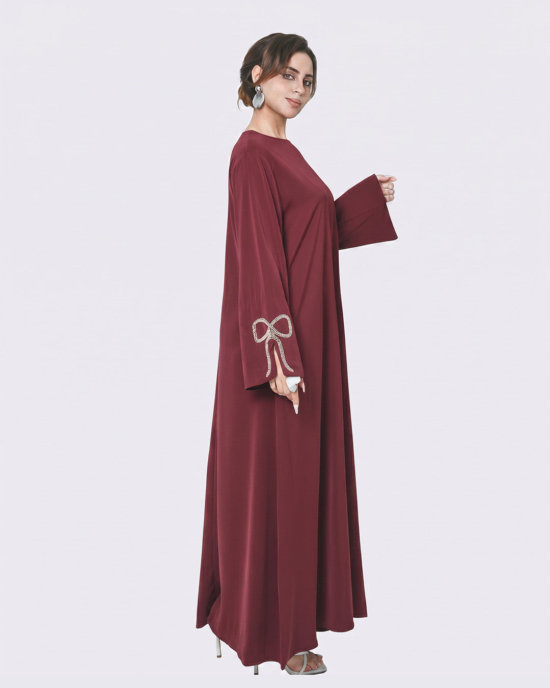 Woman wearing a burgundy dress with a bow detail on a white background