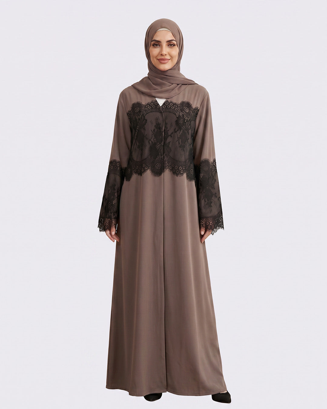 Woman wearing a brown abaya with black lace details on a white background