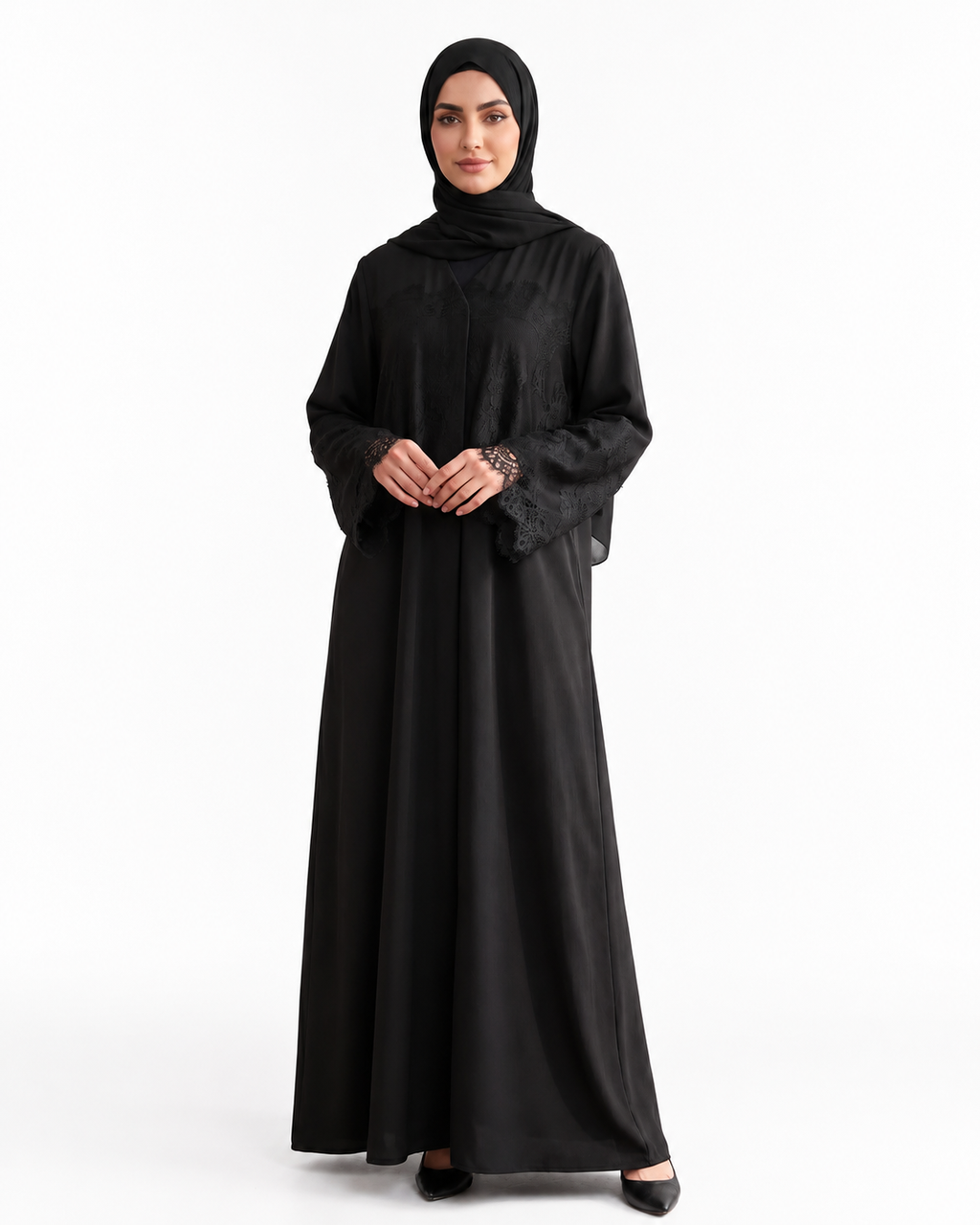 A woman modeling a full-length black abaya with a matching black hijab, standing against a plain white studio background.