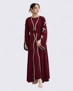 Woman wearing a burgundy dress with white accents on a light gray background