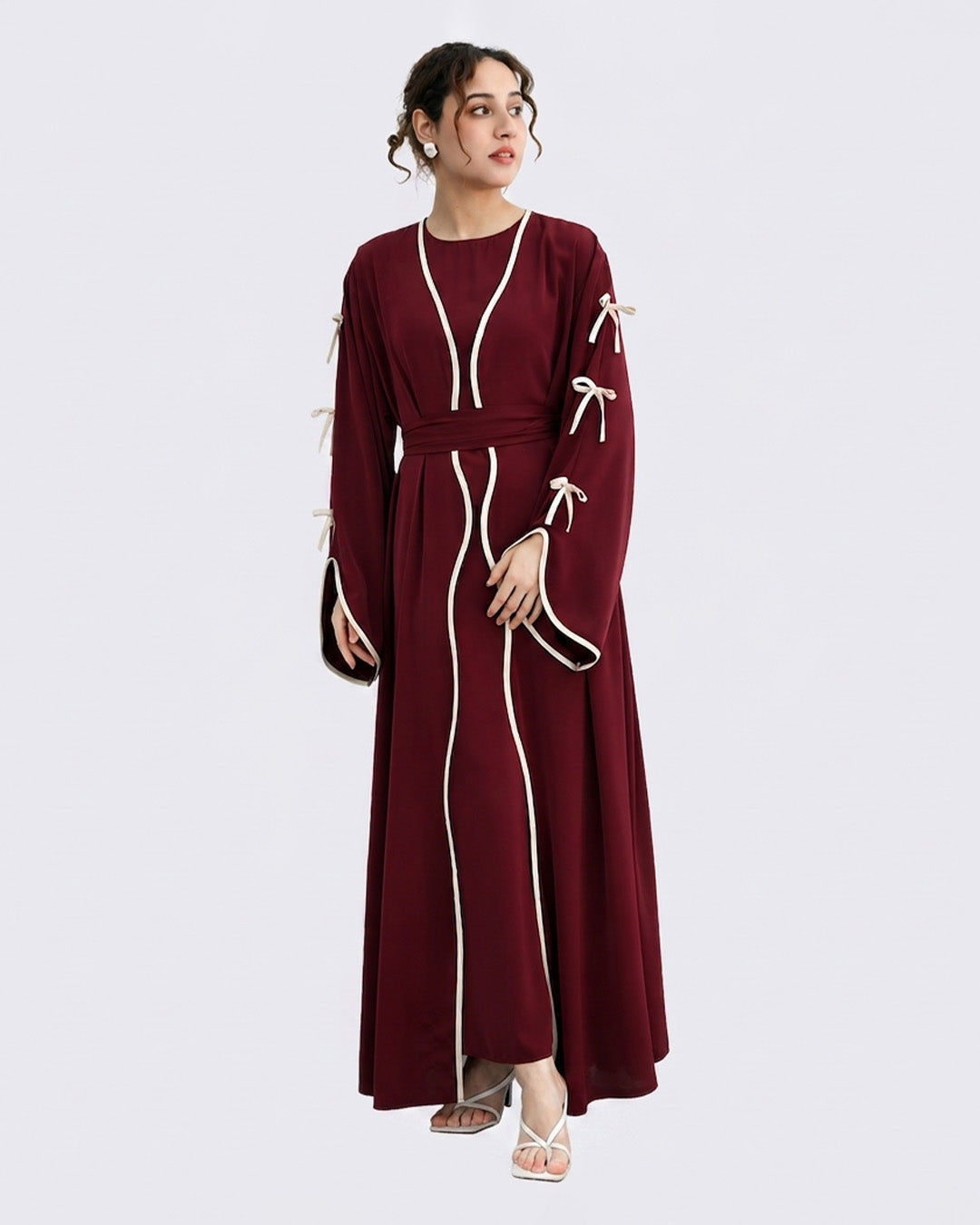 Woman wearing a burgundy dress with white accents on a light gray background