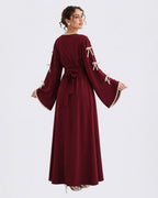 Woman wearing a burgundy dress with white trim on a white background