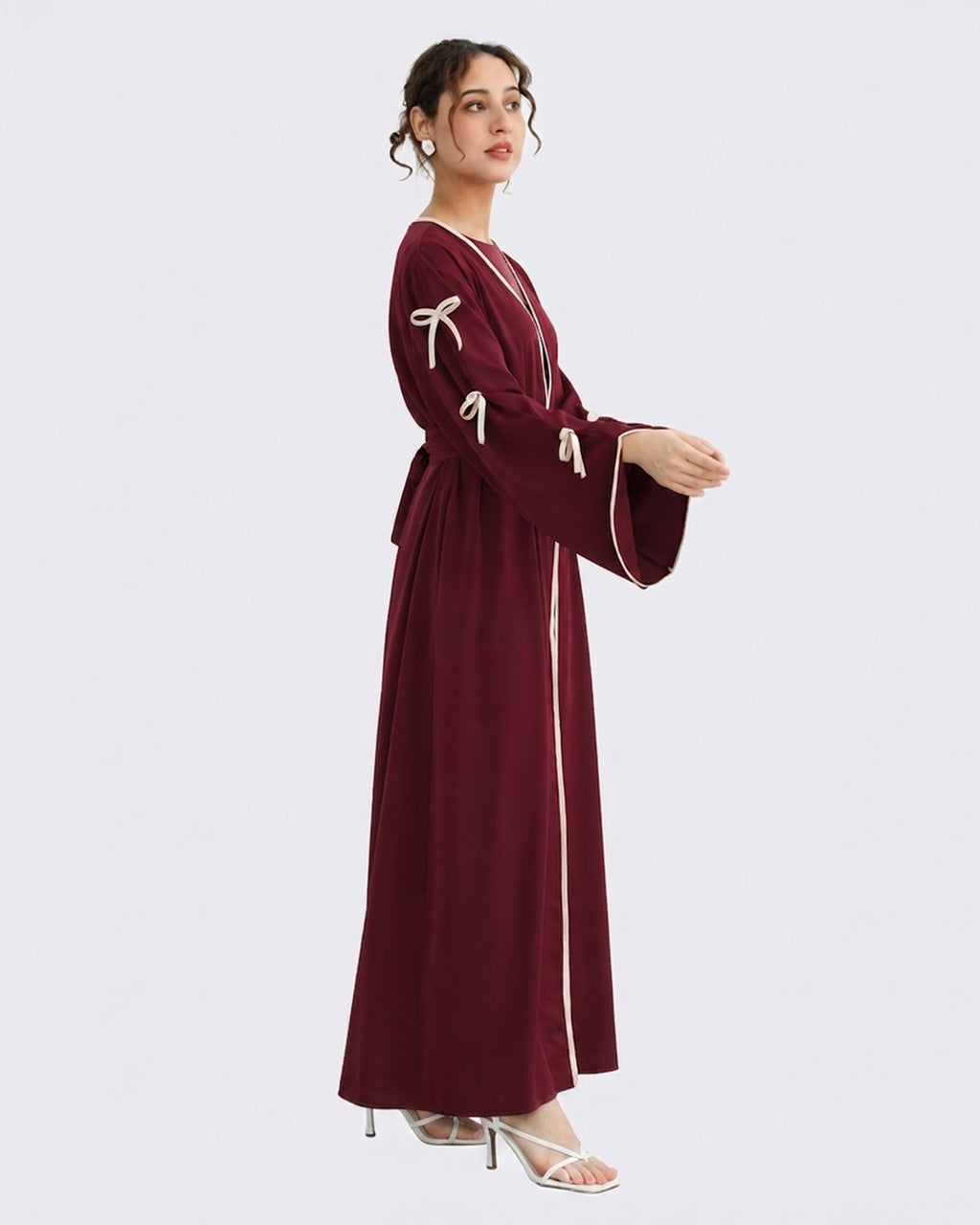 Woman wearing a burgundy dress with white accents on a light gray background
